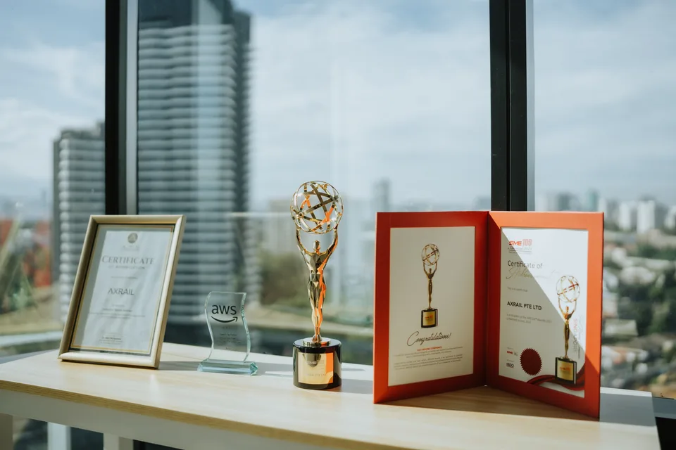 The SME100 certificate of achievement displayed with Axrail's other awards